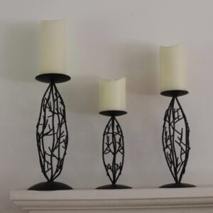 Three decorative candle holders sit on a shelf.