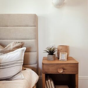 a bedroom with a bed, nightstand, and lamp