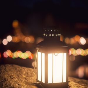 a lit lantern sitting on top of a rock