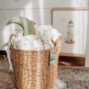 a wicker basket filled with blankets on top of a rug